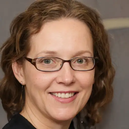 A happy woman in her 30s with healthy, shiny hair.