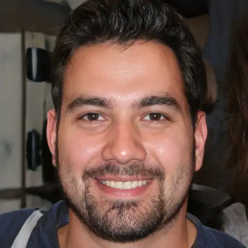 A smiling Latino man in his 30s, showing off his clear skin.