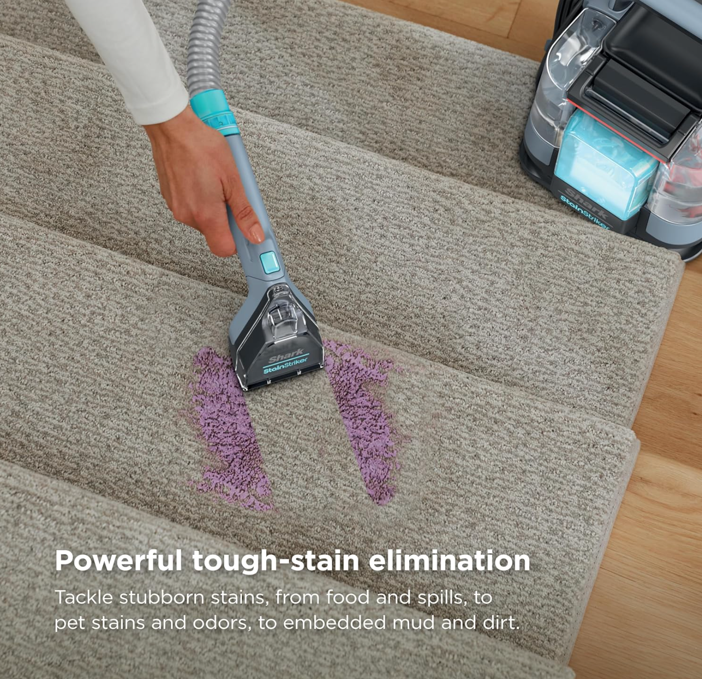 A person using the Shark StainStriker on stairs to clean carpeted steps.