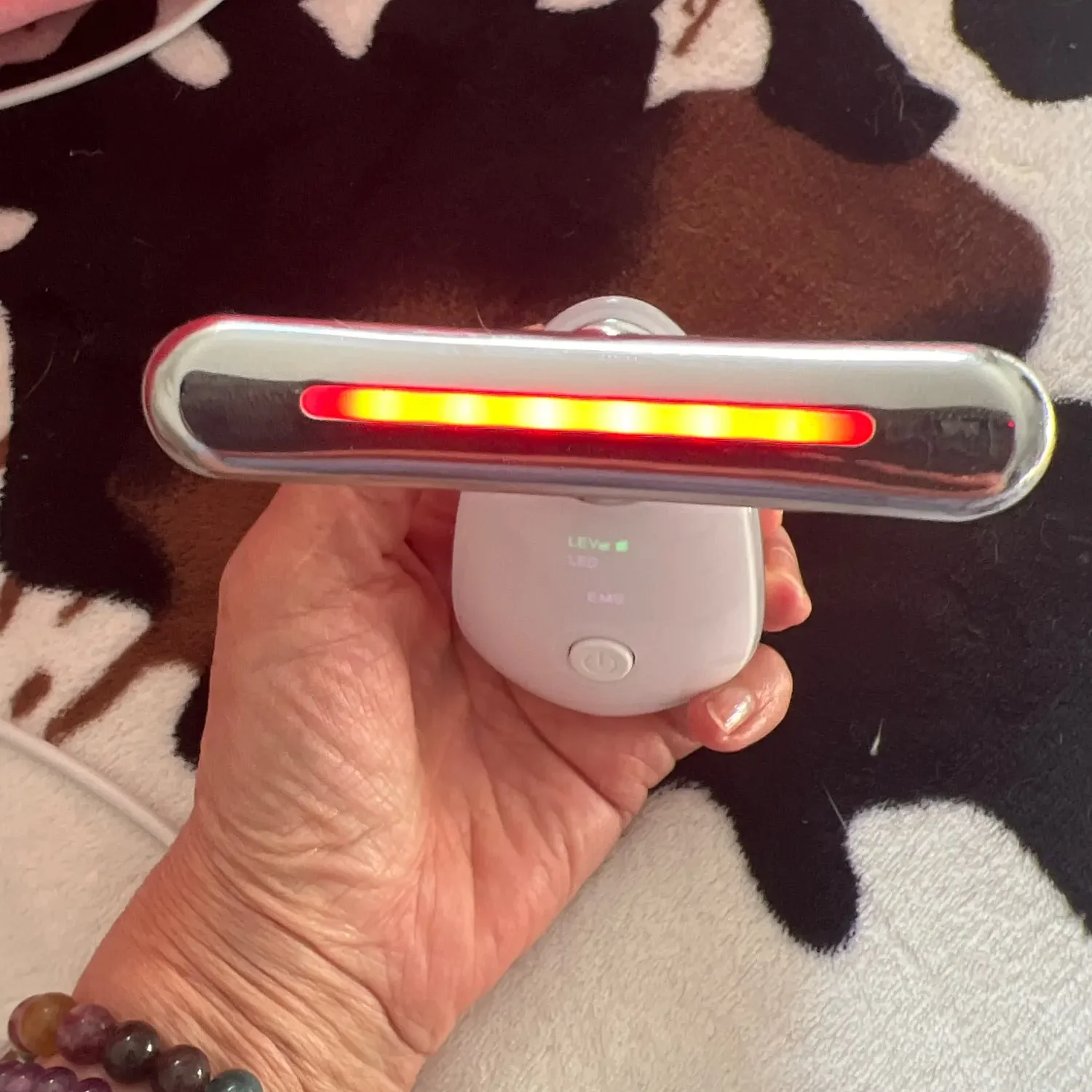 Woman applying the complimentary Collagen Boost Serum after using The Neck Sculptor