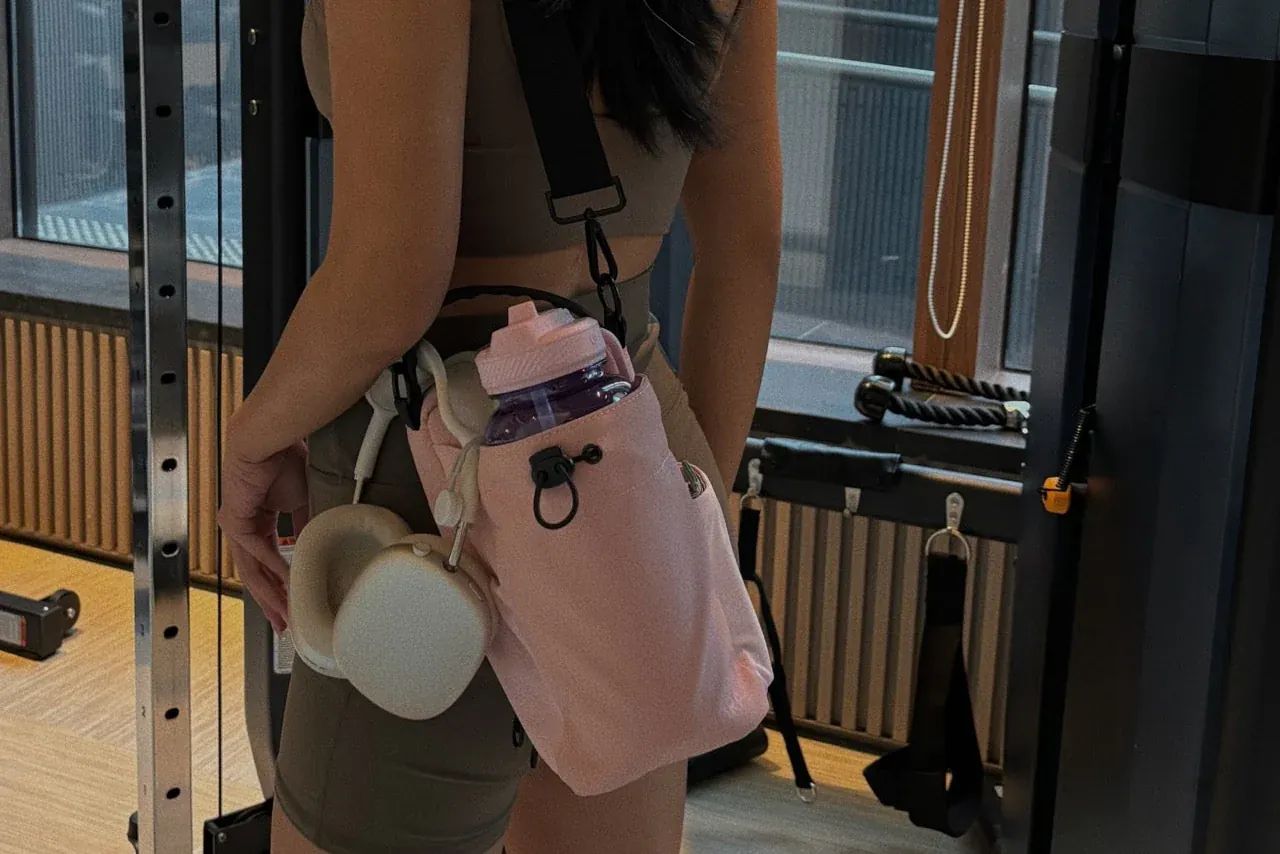 Elegant gym girl with her phone and bottle secured by the magnetic holder.