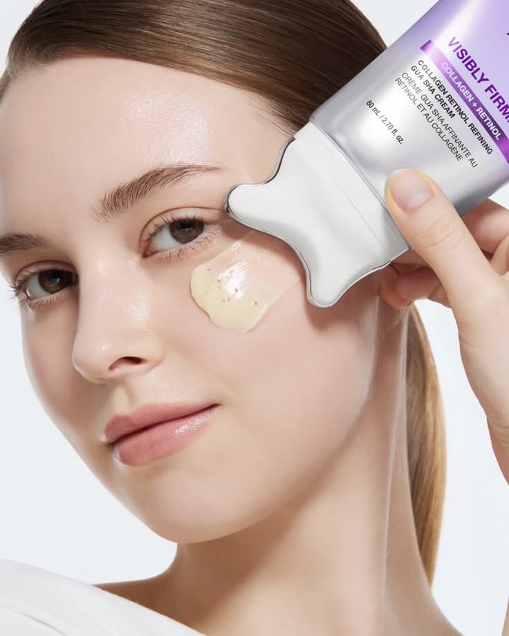 Woman applying neck cream with guasha roller