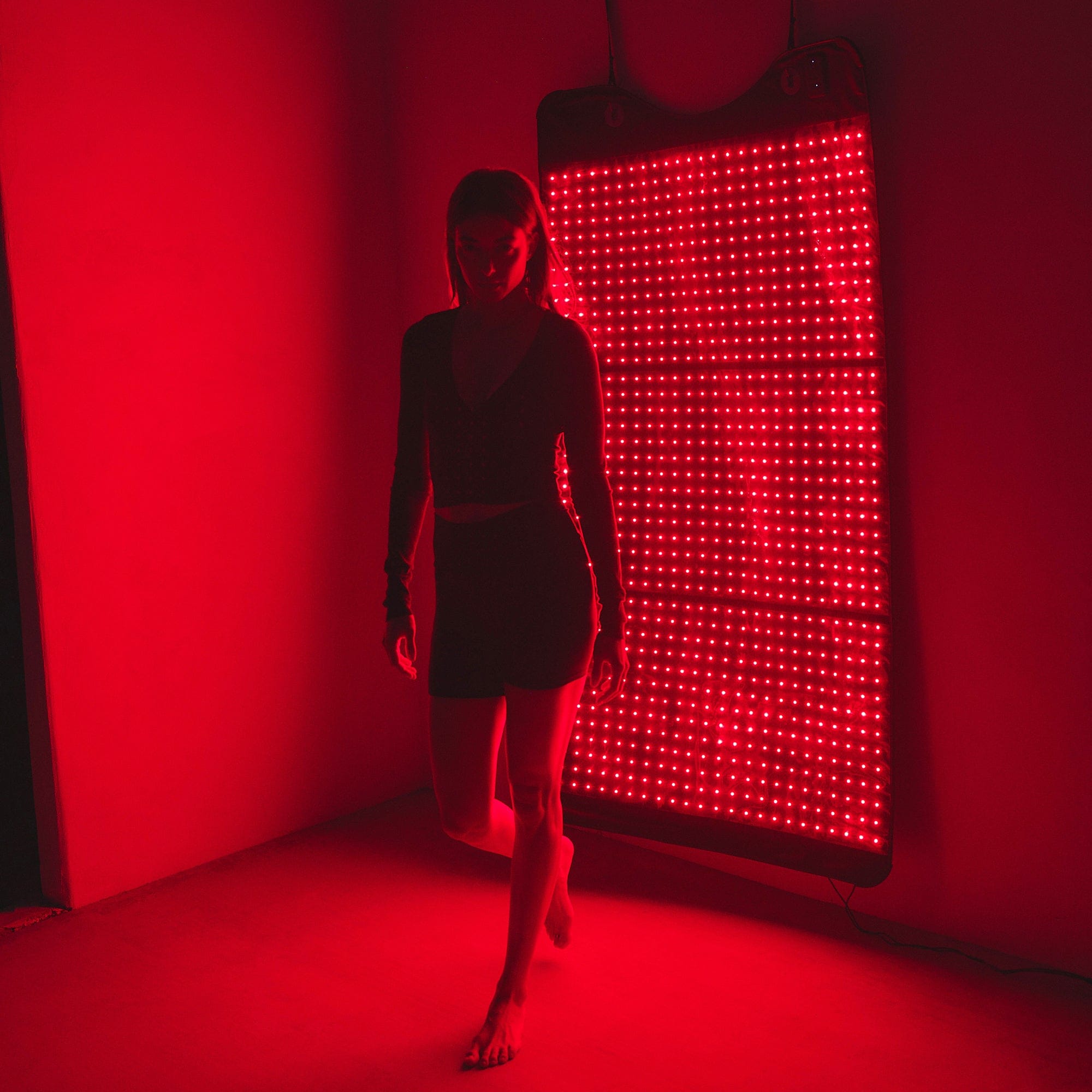 Person using a red light therapy device on their arm