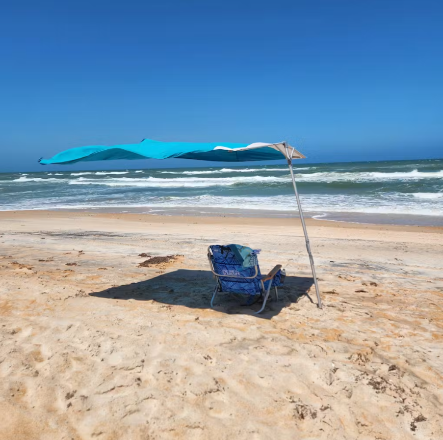 Customer easily anchoring the Solbello umbrella with its integrated stake.
