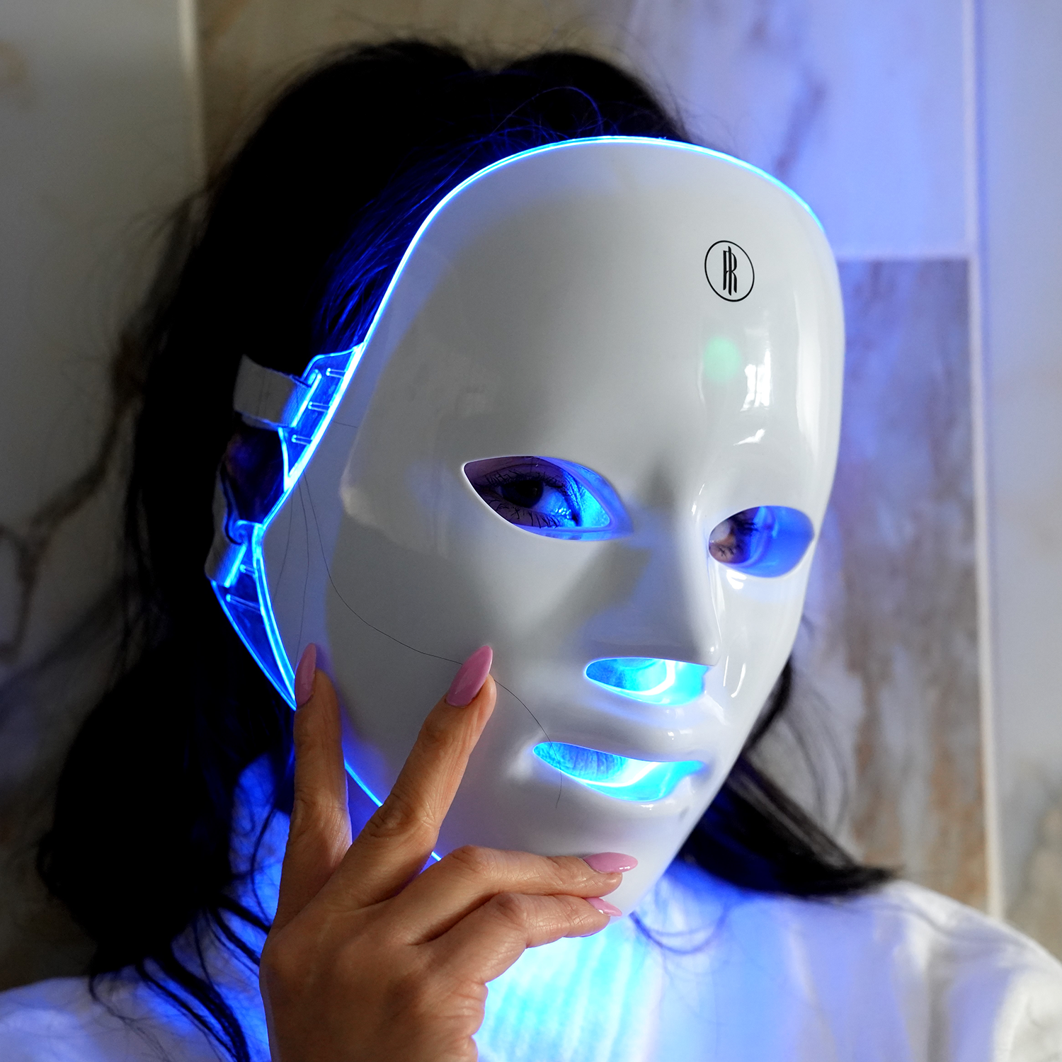 Woman relaxing with the wireless LED face mask on
