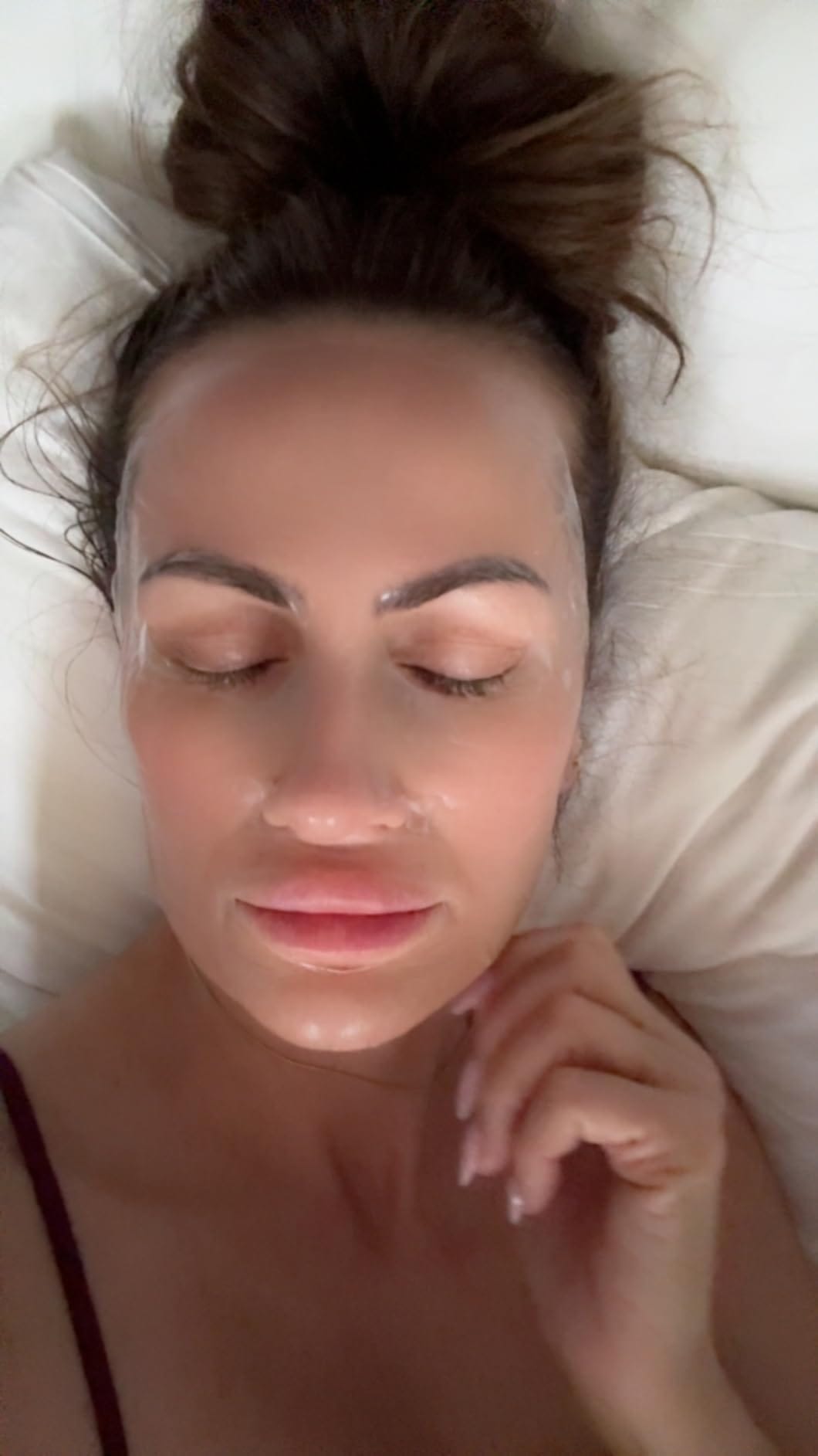 Woman applying sleeping mask before bed