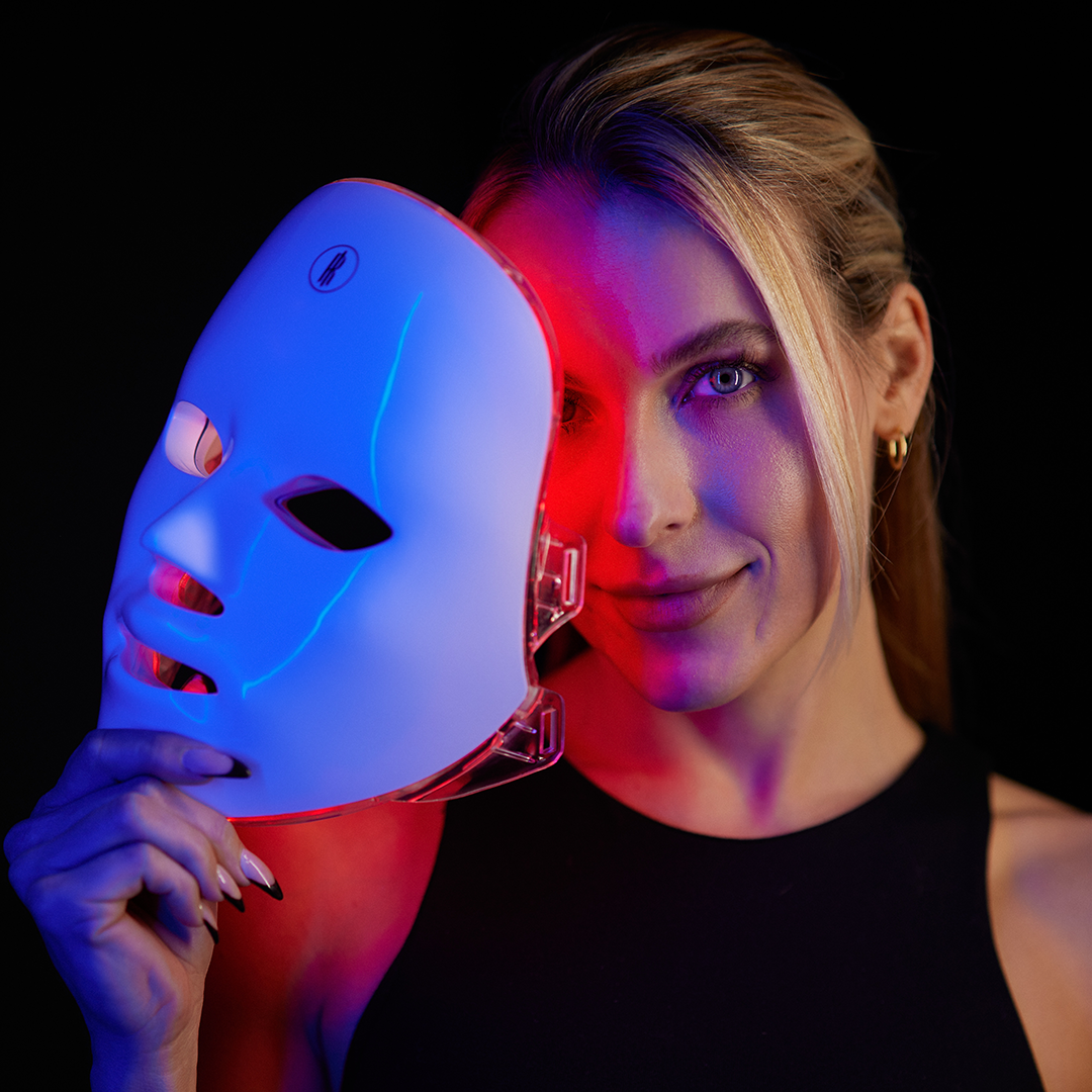 Woman smiling with the wireless LED light therapy face mask on