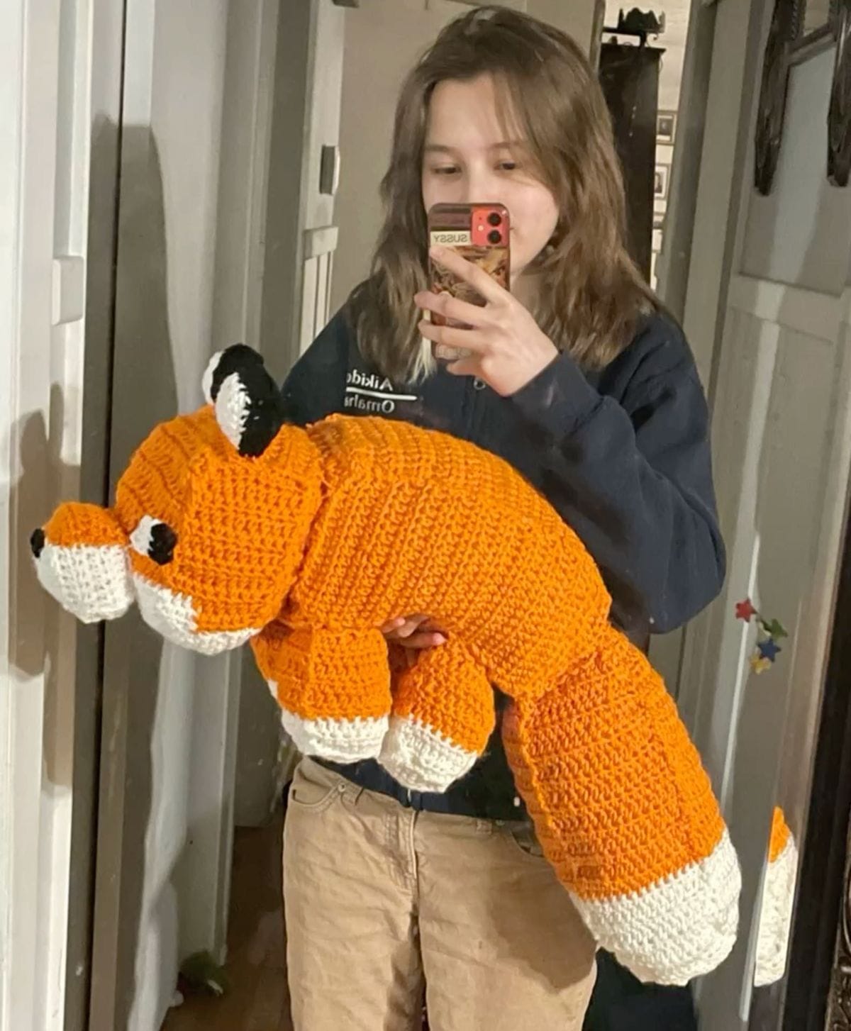 Hands working on a small amigurumi keychain, showcasing intricate detail.