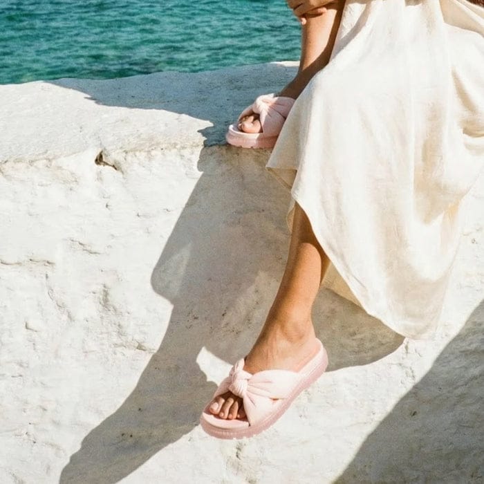 Lifestyle shot of someone wearing beige sandals on a sunny day