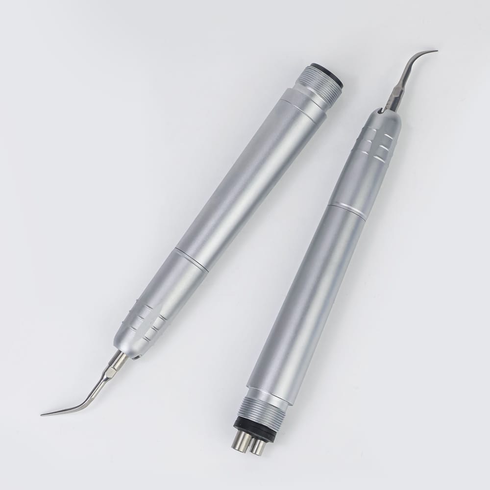 A dental professional using the scaler tool on a patient to clean teeth