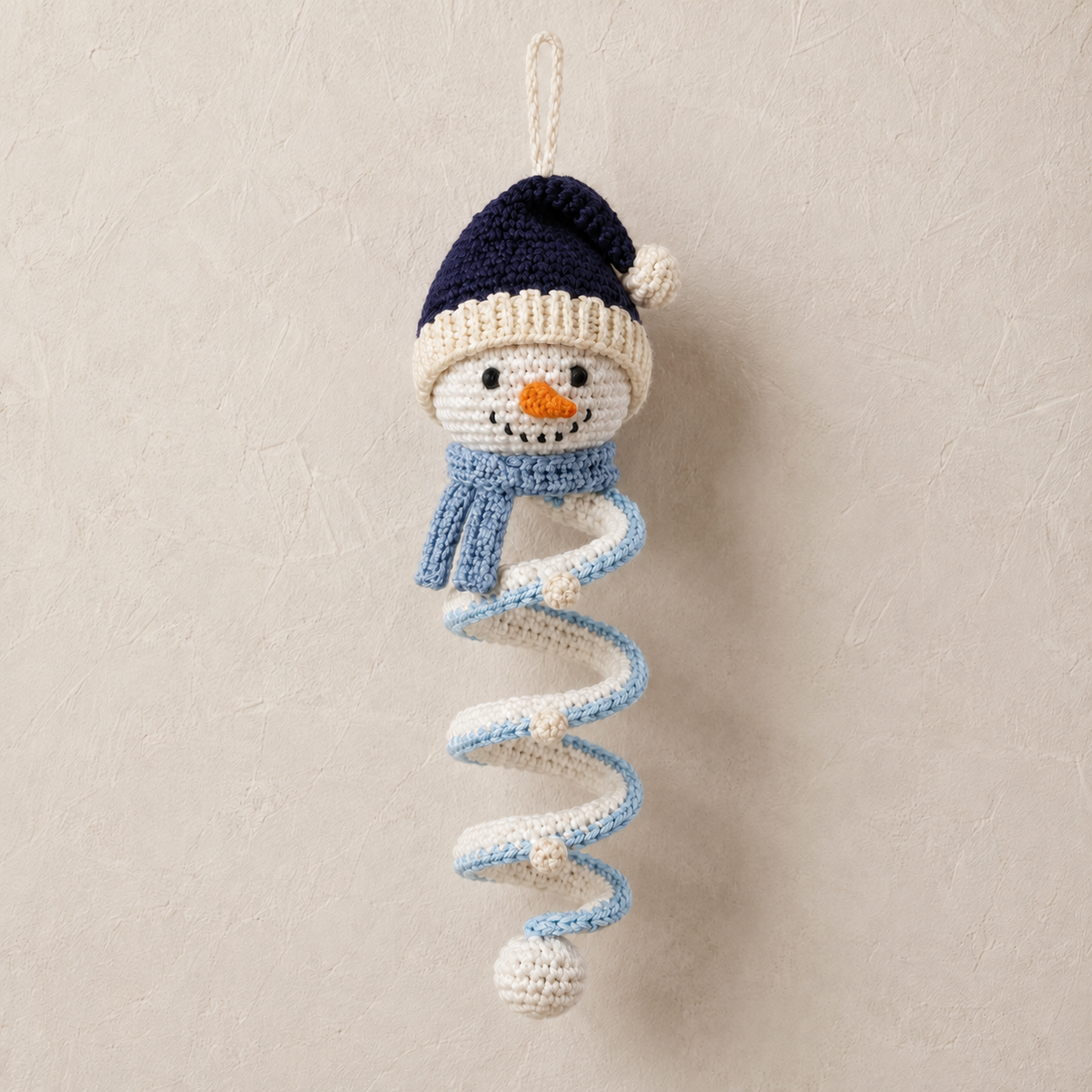 Four unique snowman spiral crochet ornaments hanging as Christmas decorations