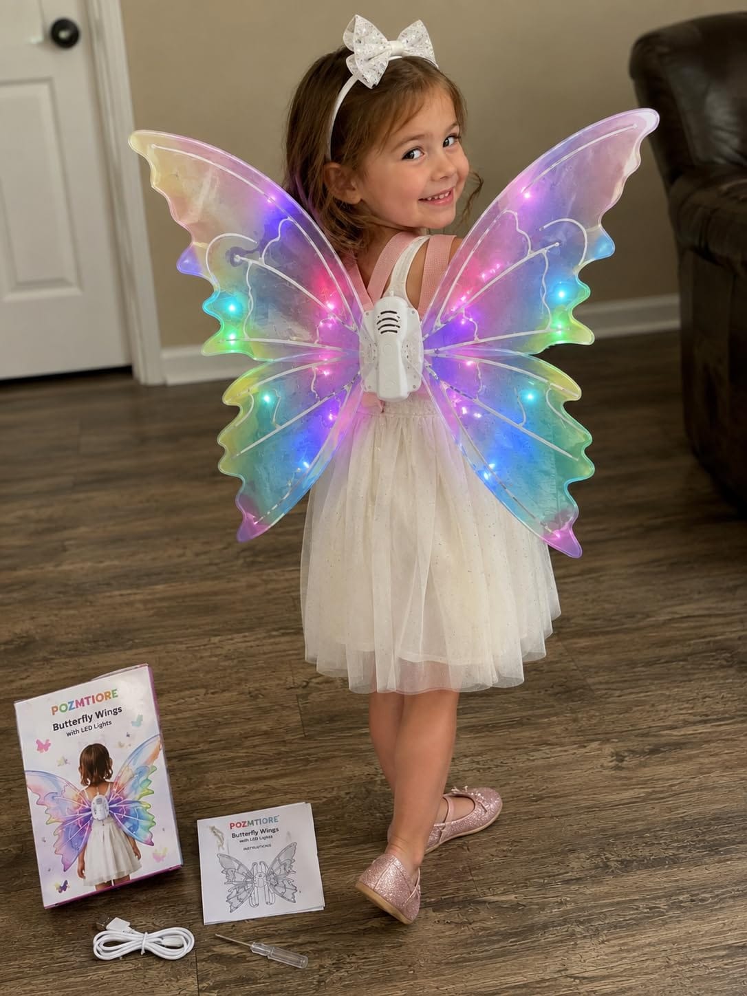 Little girl happily wearing sparkling fairy wings